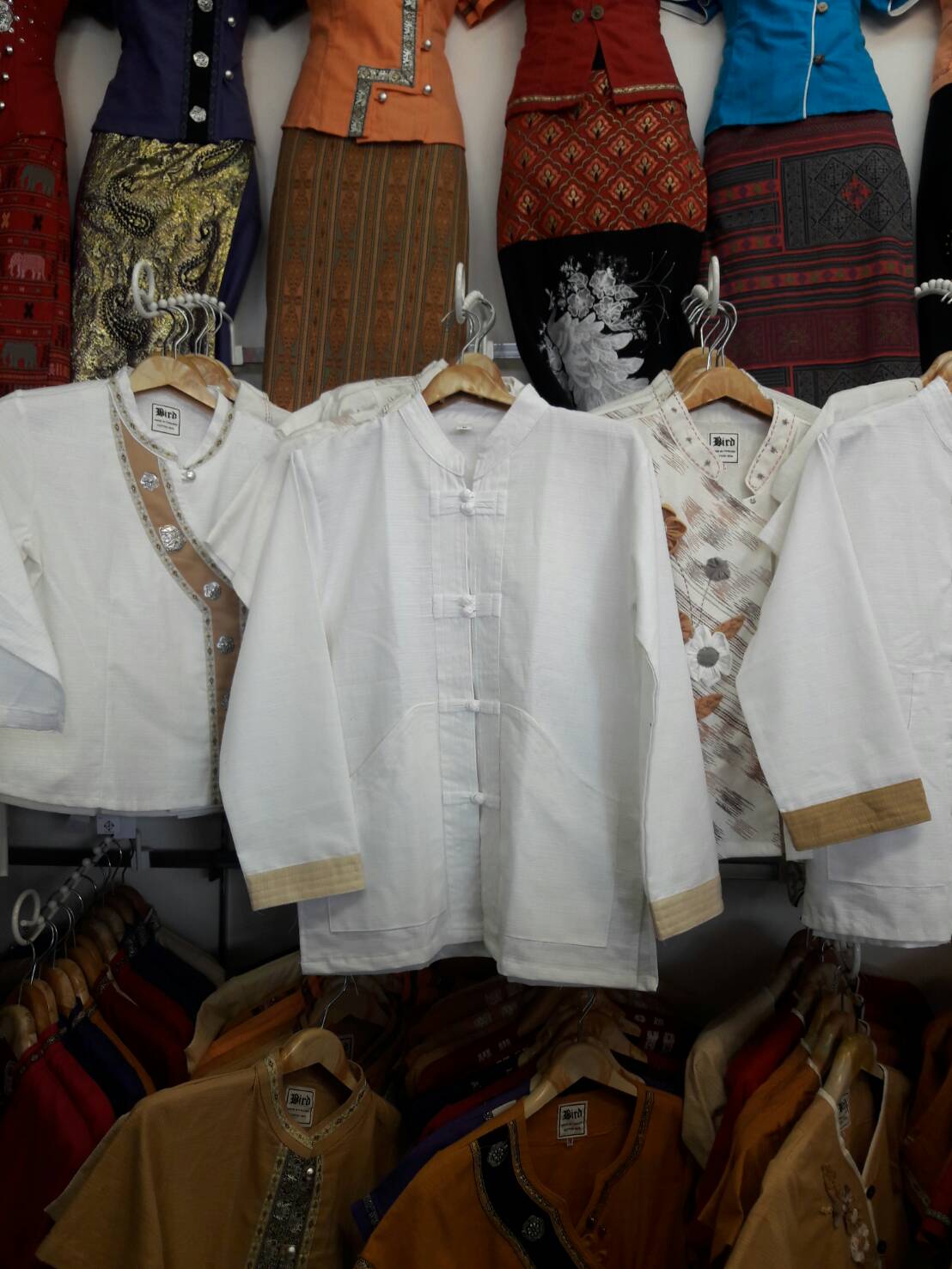 เสื้อผ้าไทยชายแขนยาวสีขาว เสื้อผ้าฝ้ายชายแต่งกระดุ้มปั้นแต่งขลิบสีครีม เสื้อผ้าพื้นเมืองชายวัยรุ่นกระเป๋าเว้า