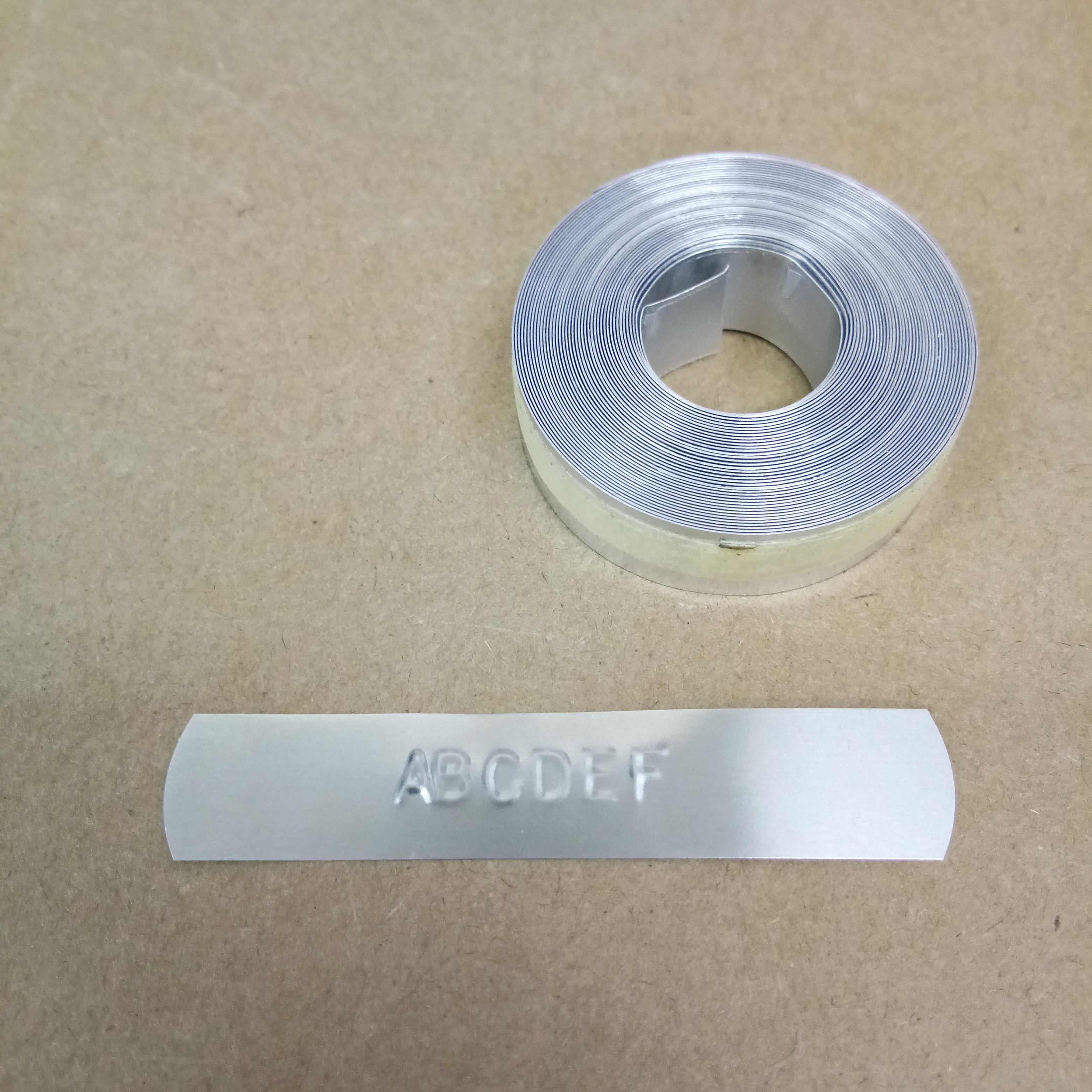 ม้วนป้ายอลูมิเนียมมีเทปกาวในตัว 12mm*3.65m สำหรับเครื่องพิมพ์ DYMO Aluminium with Adhesive TAG EMBOSSER