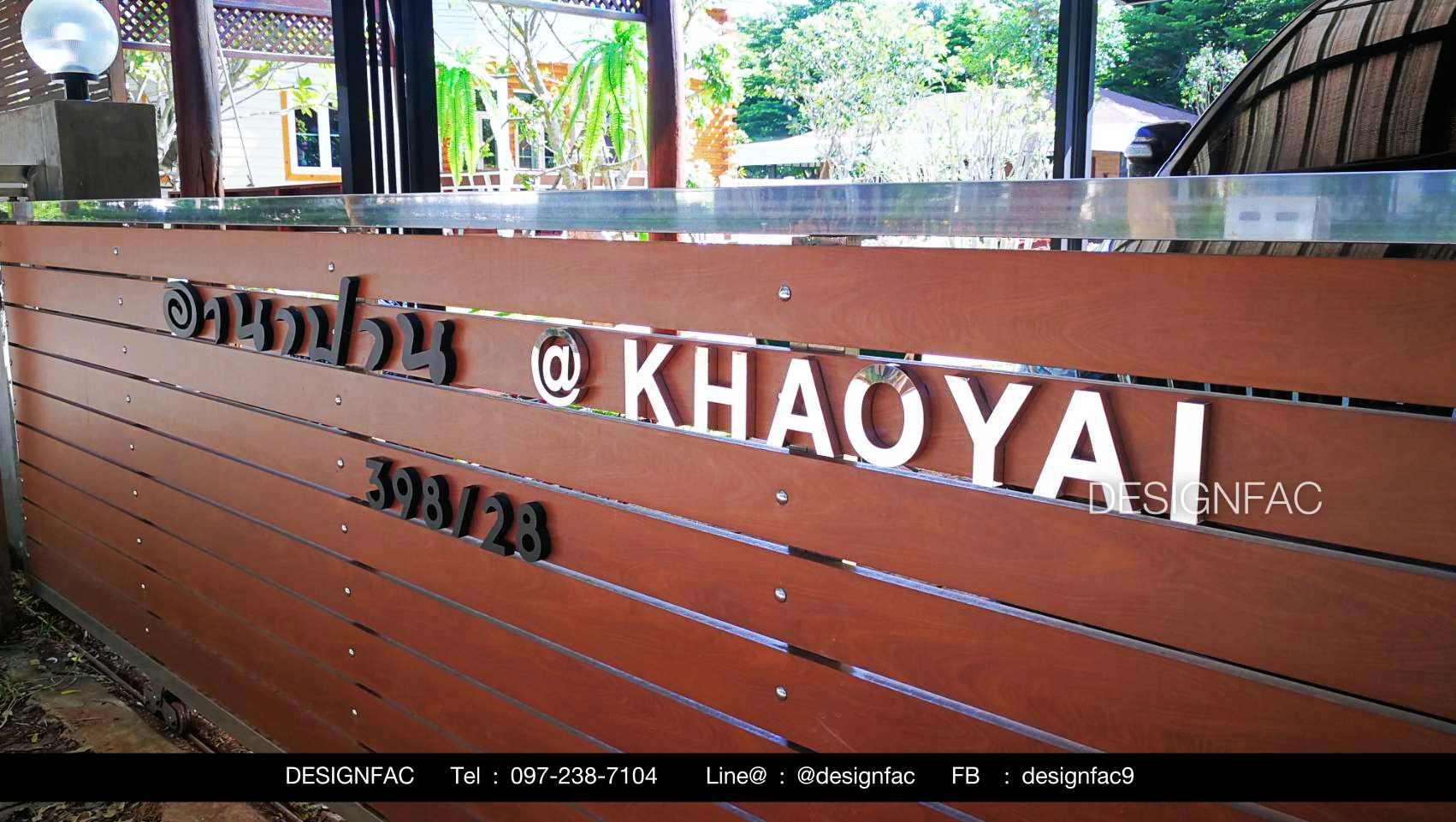 ป้ายเลขที่บ้านและชื่อบ้านติดบนประตูไม้