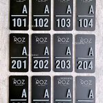 ป้ายห้องพัก The Roz อะคริลิคพื้นดำ ตัวอักษรสีขาว ลายนูนมีมิติ สไตล์โมเดิร์น มินิมอล มูจิ